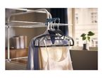 Clothes drying rack with shirts and a tank top hanging on black hangers.