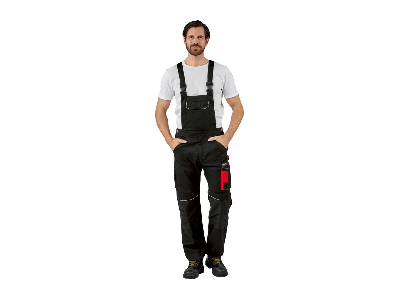 Man in black work overalls with red accents and a white t-shirt.