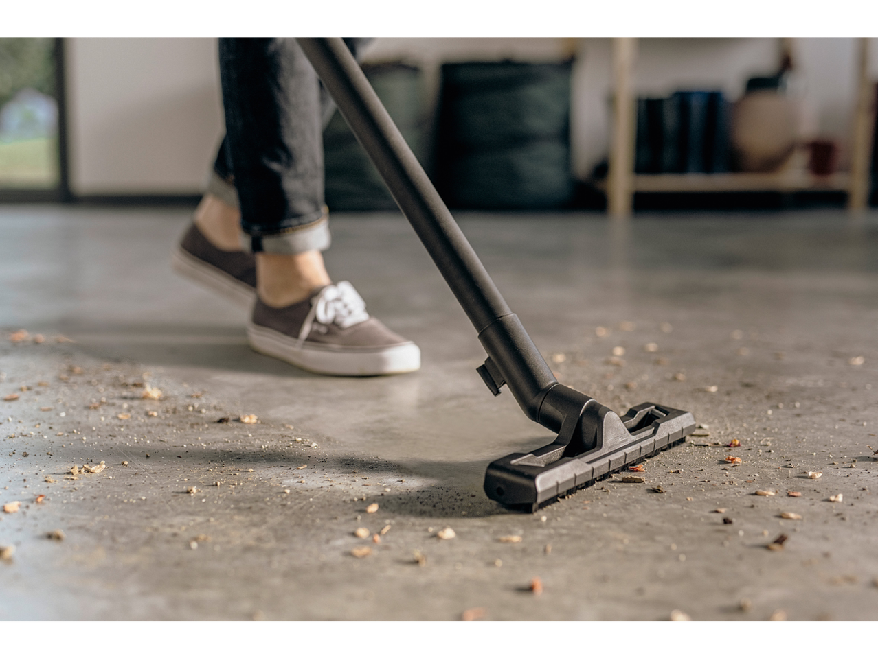 A vacuum cleaner cleans a garage floor.
