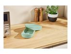 A SilverCrest microwave, salt and pepper grinders, and a plant on a wooden kitchen counter.