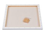 Back of a blank white stretched canvas with wooden frame and a bag of wooden wedges.