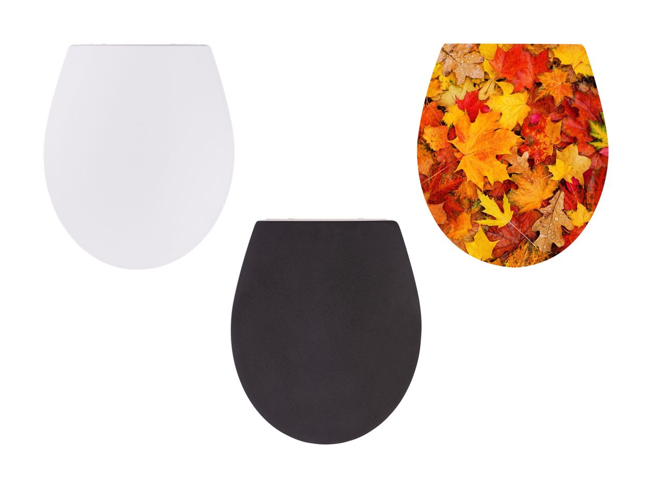 Drei Toilettensitze: weiß, schwarz und Herbstmotiv.