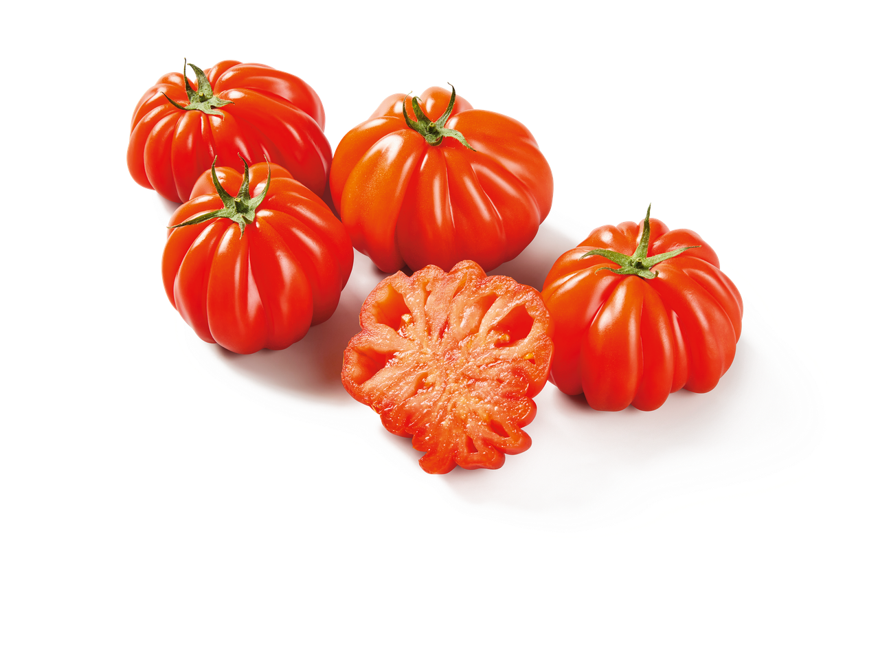 Tomates côtelées rouges entières et coupées en deux sur fond noir.