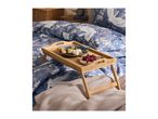 Breakfast in bed with a blue floral duvet cover and a wooden bed tray.