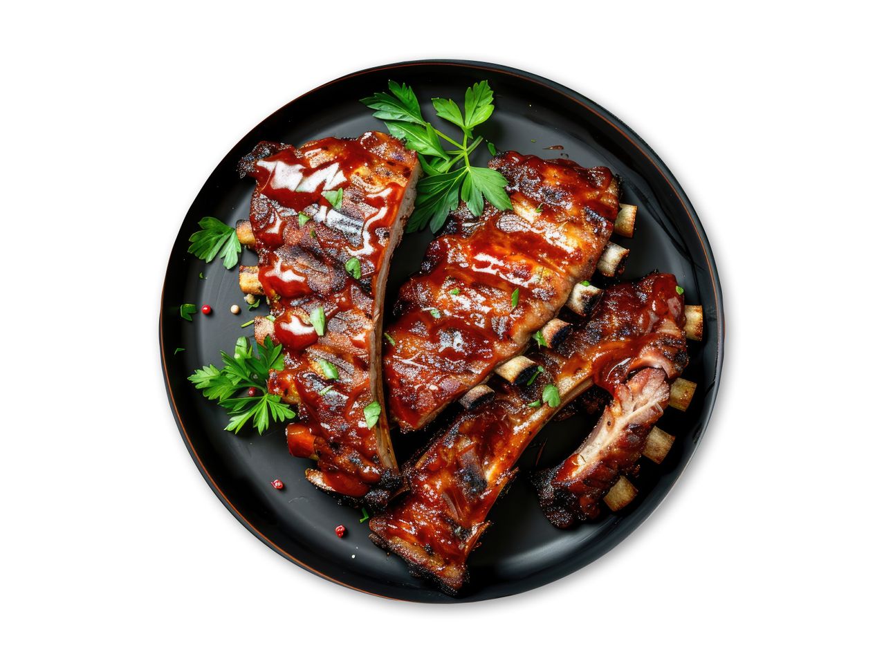 Grillede spareribs med barbecuesauce og persille på en sort tallerken.