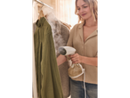 Mulher a vaporizar uma camisa verde com uma escova a vapor Silvercrest®.