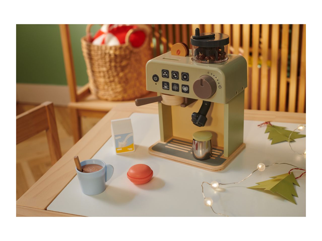 Toy coffee machine with a cup of hot chocolate, milk carton, and Christmas decorations.
