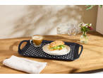 Tavă de mic dejun cu cafea, sandviș și flori pe o masă de lemn.
