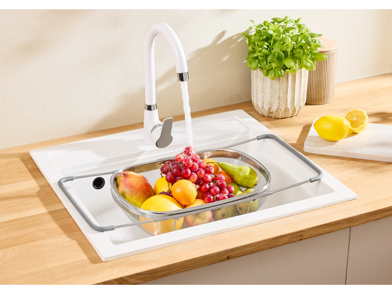 Σουρωτήρι Silvercrest® με φρούτα στον νεροχύτη κουζίνας, τρεχούμενο νερό.