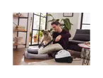 Homem a limpar almofadas e cama de cachorro com um vaporizador.