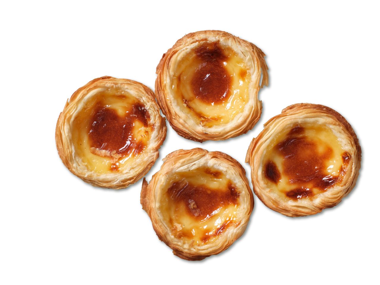 Neli Portugali pastel de nata kooki küpsetatud karamelliseeritud koorikuga.