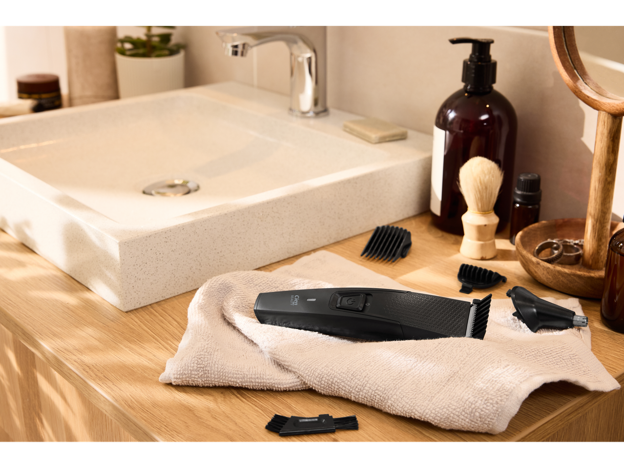 Cien BEAUTY trimer za kosu i dodaci na ručniku pored kupaonskog umivaonika.