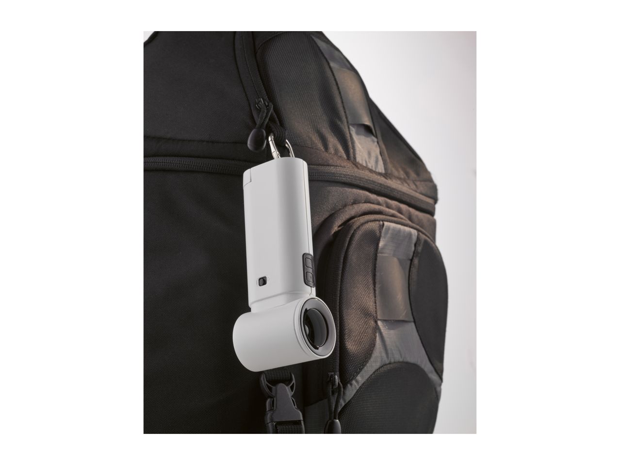 White portable speaker hanging from a black backpack.