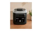 A black and silver multi-cooker with a digital display on a wooden surface.