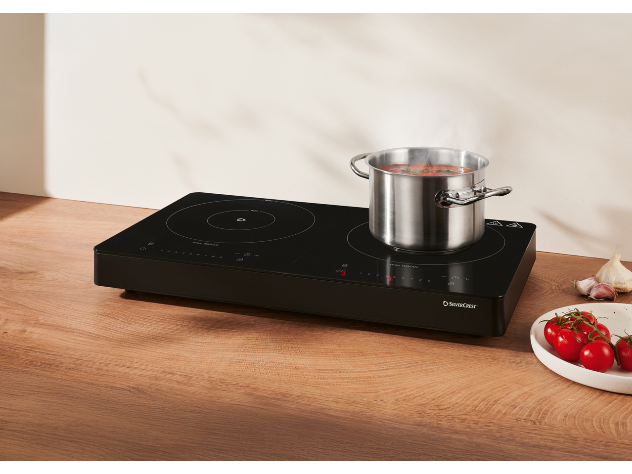 Silvercrest® dupla indukciona ploča za kuvanje sa loncem paradajz sosa koji se puši.