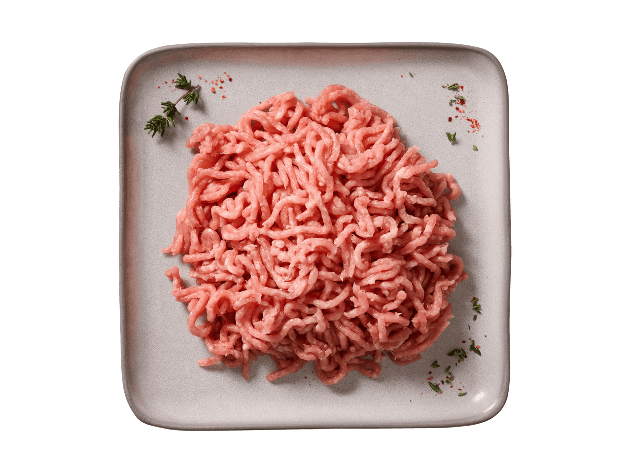 Hackfleisch auf einem Teller mit Kräutern und Gewürzen