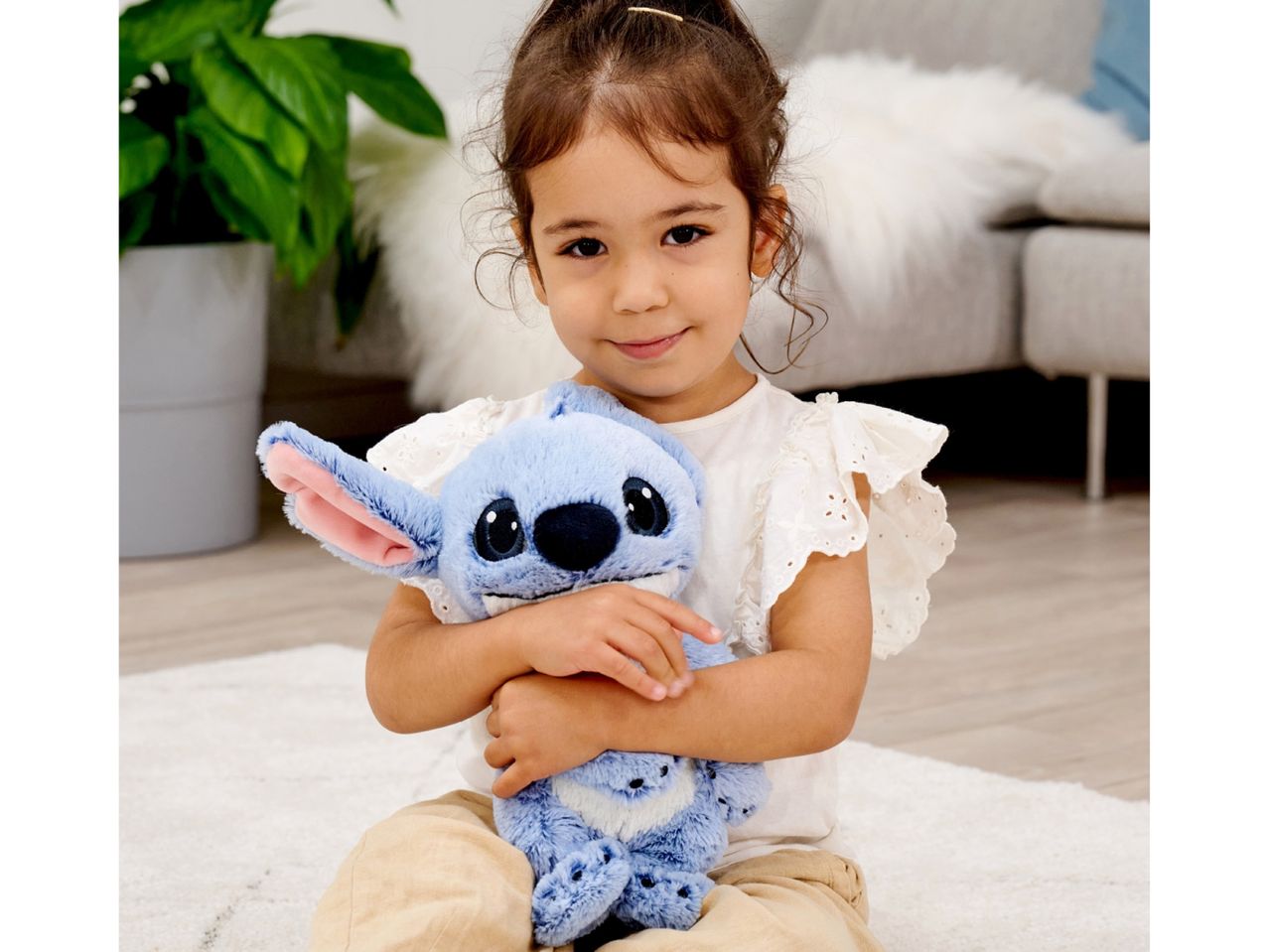 A young girl hugs a plush Stitch toy.