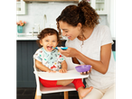 A mother feeds her happy baby with a Munchkin spoon and bowl.