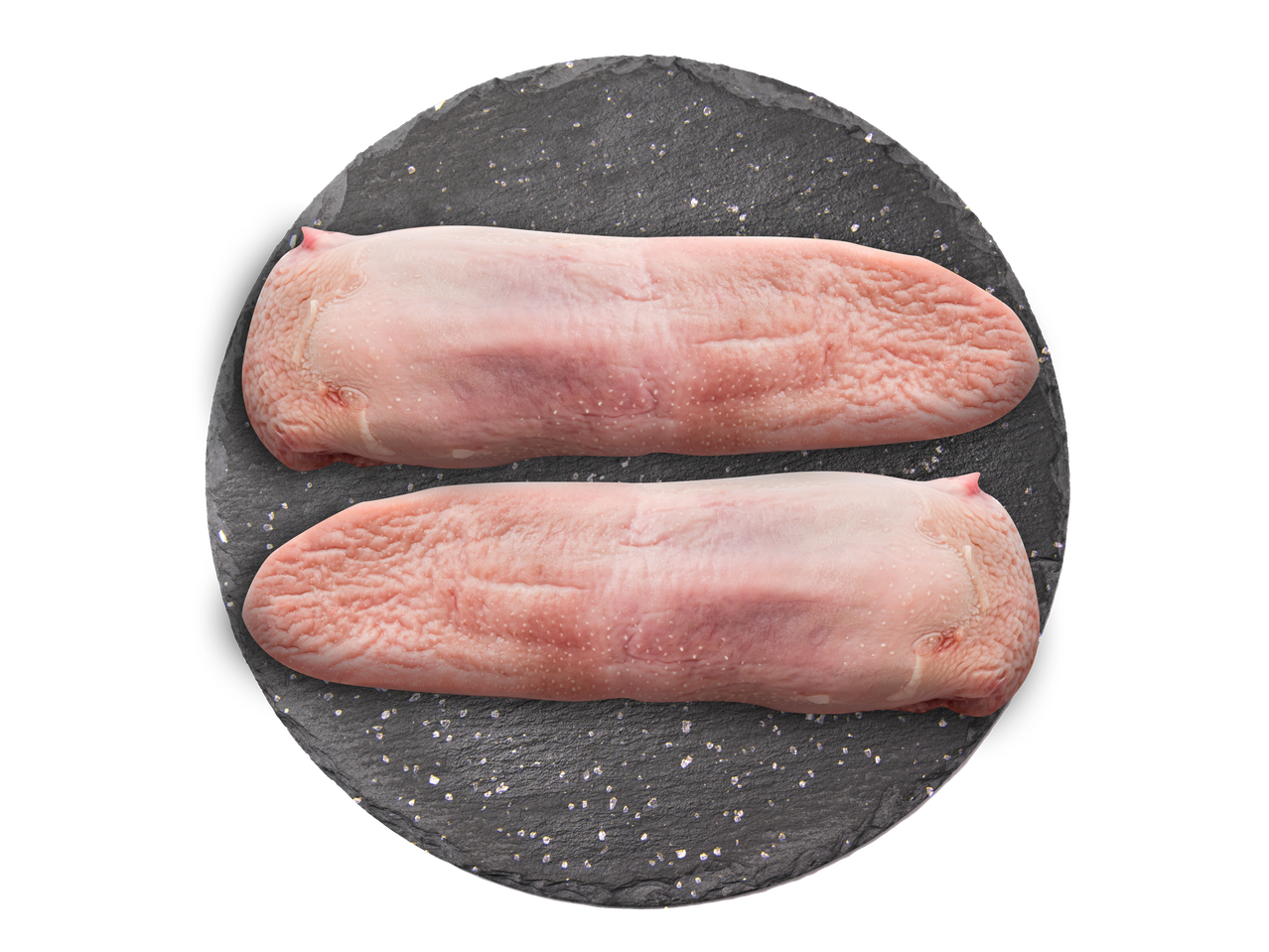 Du dvi žalios jautienos liežuviai ant tamsaus skalūno lentos.