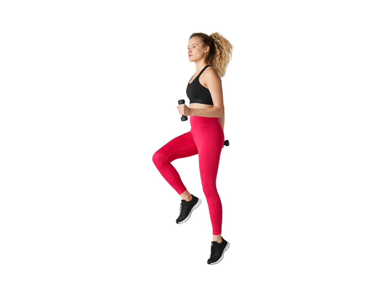 Žena u CRIVIT funkcionalnim helankama i sportskom grudnjaku, drži tegove.