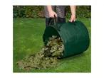 A person emptying a green garden waste bag filled with leaves onto a lawn.