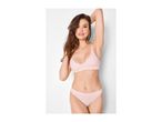 Woman in light pink ribbed bralette and matching briefs, smiling with hands behind her head.
