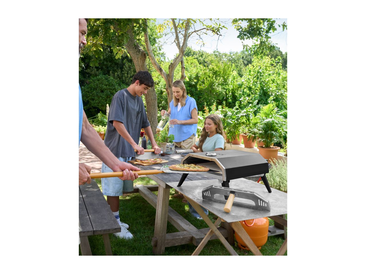 Family making pizzas outdoors with a pizza oven and pizza peels.