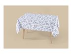 White tablecloth with a blue leaf pattern draped over a wooden table.