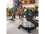 A person uses a Parkside wet/dry vacuum cleaner to clean a wet floor.