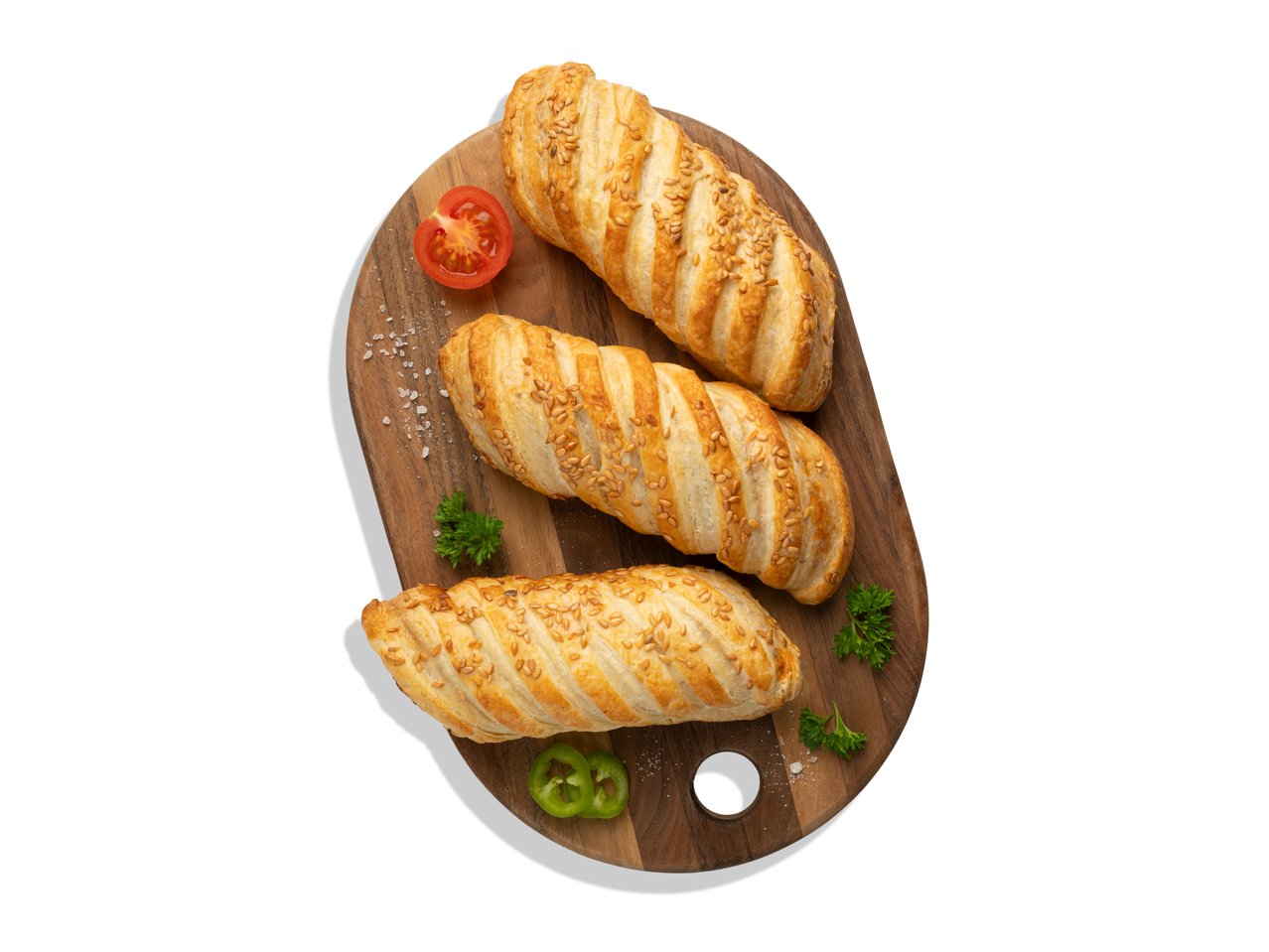 Három BBQ húsos párna szezámmaggal, paradicsommal, chilivel és petrezselyemmel egy fa deszkán.