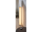 A tall, cylindrical floor lamp with a remote control sits on a side table.