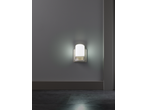 Luz noturna LED LIVARNO acesa, montada numa parede cinzenta acima do rodapé.