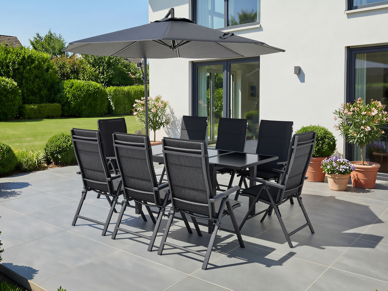 LIVARNO baštenski trpezarijski set sa crnim stolom, stolicama i suncobranom na sunčanoj terasi.
