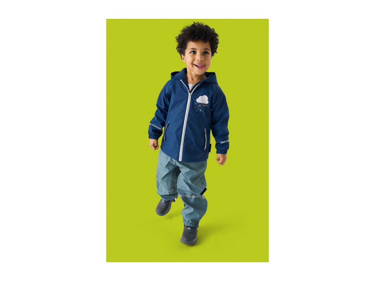 A smiling child in a blue rain jacket with a cloud and 'HAPPY DAY' text, and blue rain pants.