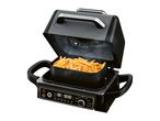 An open air fryer with a basket full of golden french fries, showing a digital display and control knob.