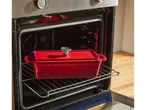 O tavă roșie din fontă pentru pâine de la SILVERCREST® într-un cuptor deschis.