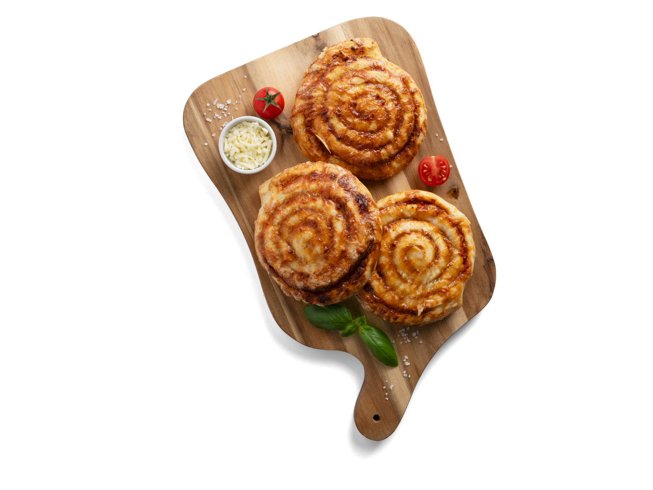 Három aranybarna pizzás csiga egy vágódeszkán paradicsommal és sajttal.