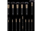 A collection of black and gold makeup brushes, including various face and eye brushes.