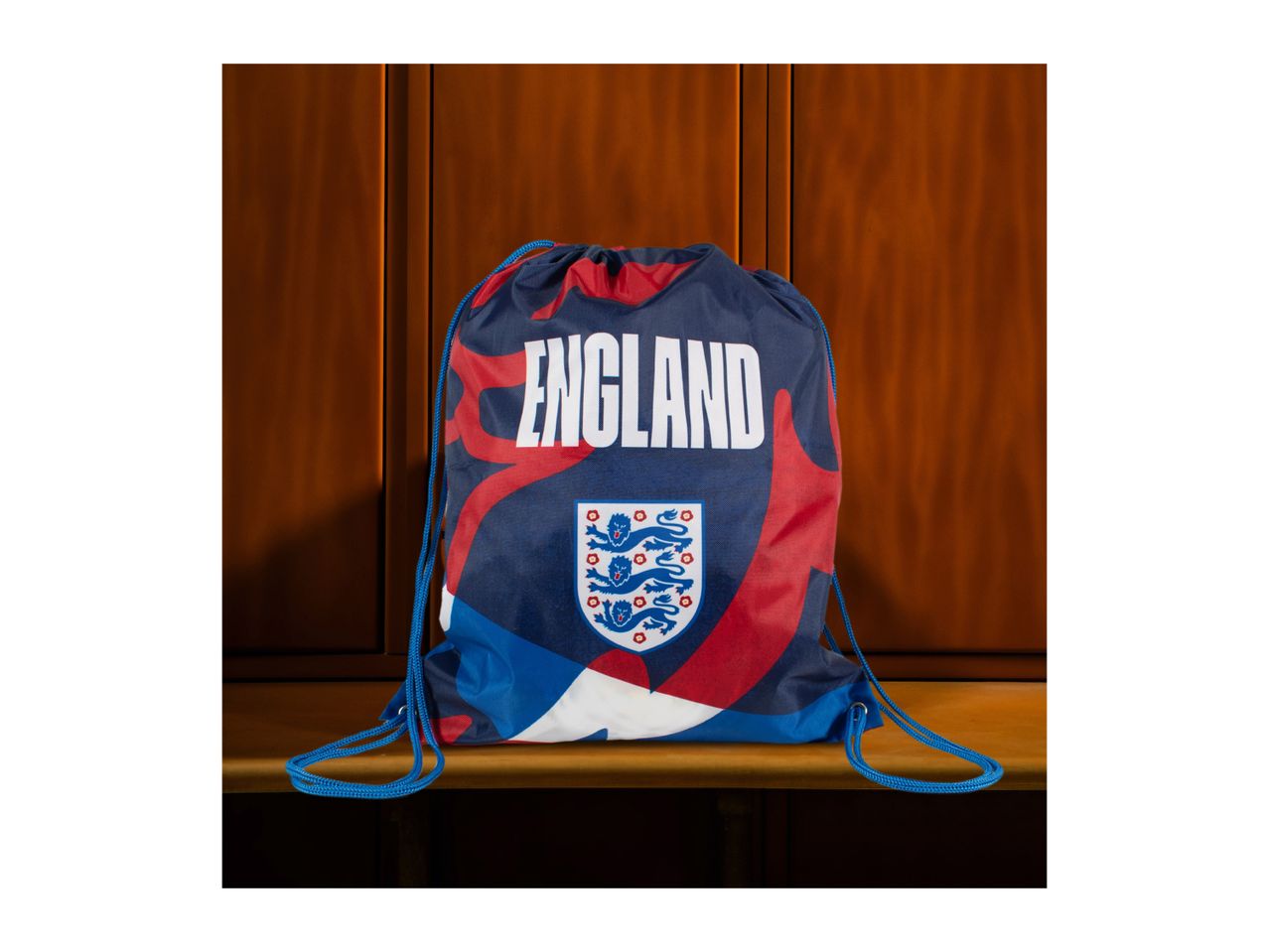 England drawstring bag with a crest and text, set against a wooden background.