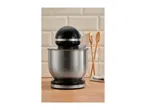 A black and silver stand mixer on a wooden countertop in front of a tiled wall.