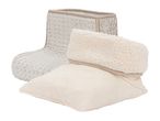 Two cozy slippers, one beige faux fur bootie and one cream knitted slipper with a sherpa cuff.