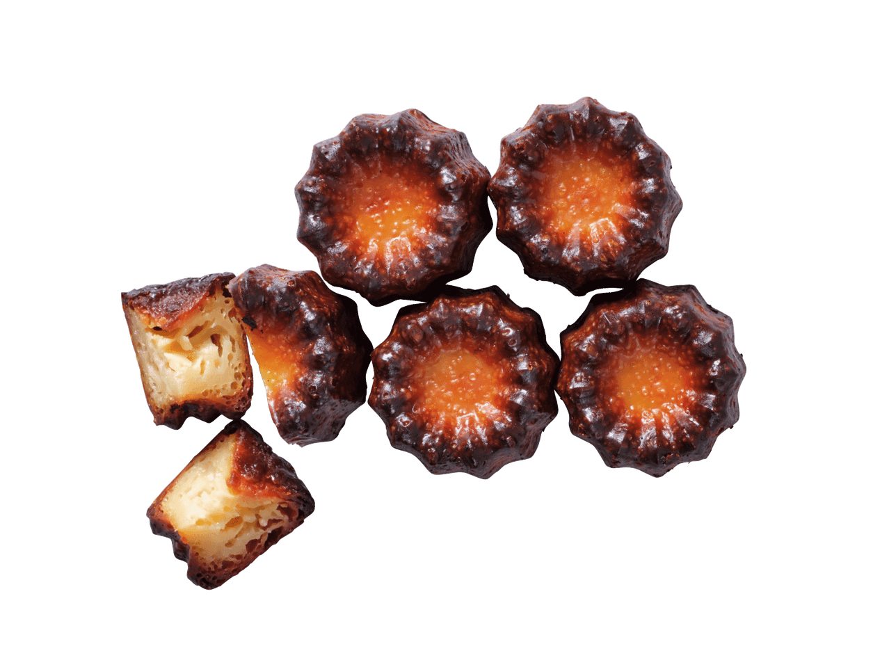 Sešas zeltaini brūnas canelés, divas no tām pārgrieztas uz pusēm, atklājot gaišu, porainu iekšpusi.