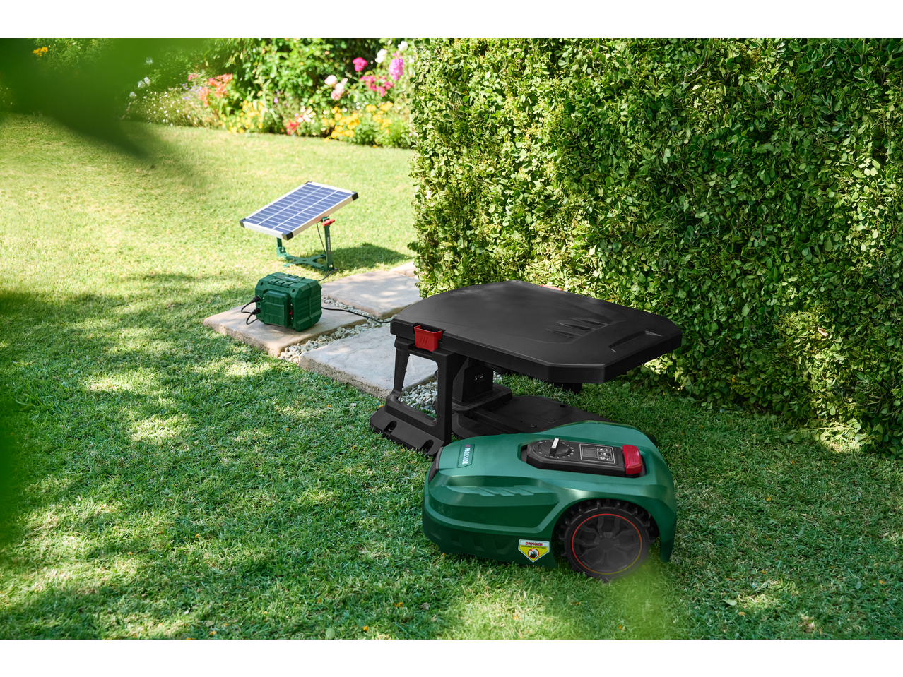 Robotic lawnmower with charging station and solar panel in a garden.
