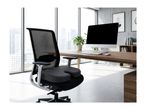 Ergonomic office chair with a coccyx cushion in a modern office setting.