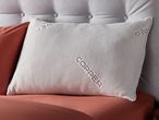 Copper Pillow resting on a terracotta colored bedsheet.