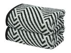 Two folded towels with a black and white geometric pattern, stacked on top of each other.