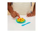 Child's hands placing play-doh meatballs on yellow play-doh spaghetti on a blue plate.