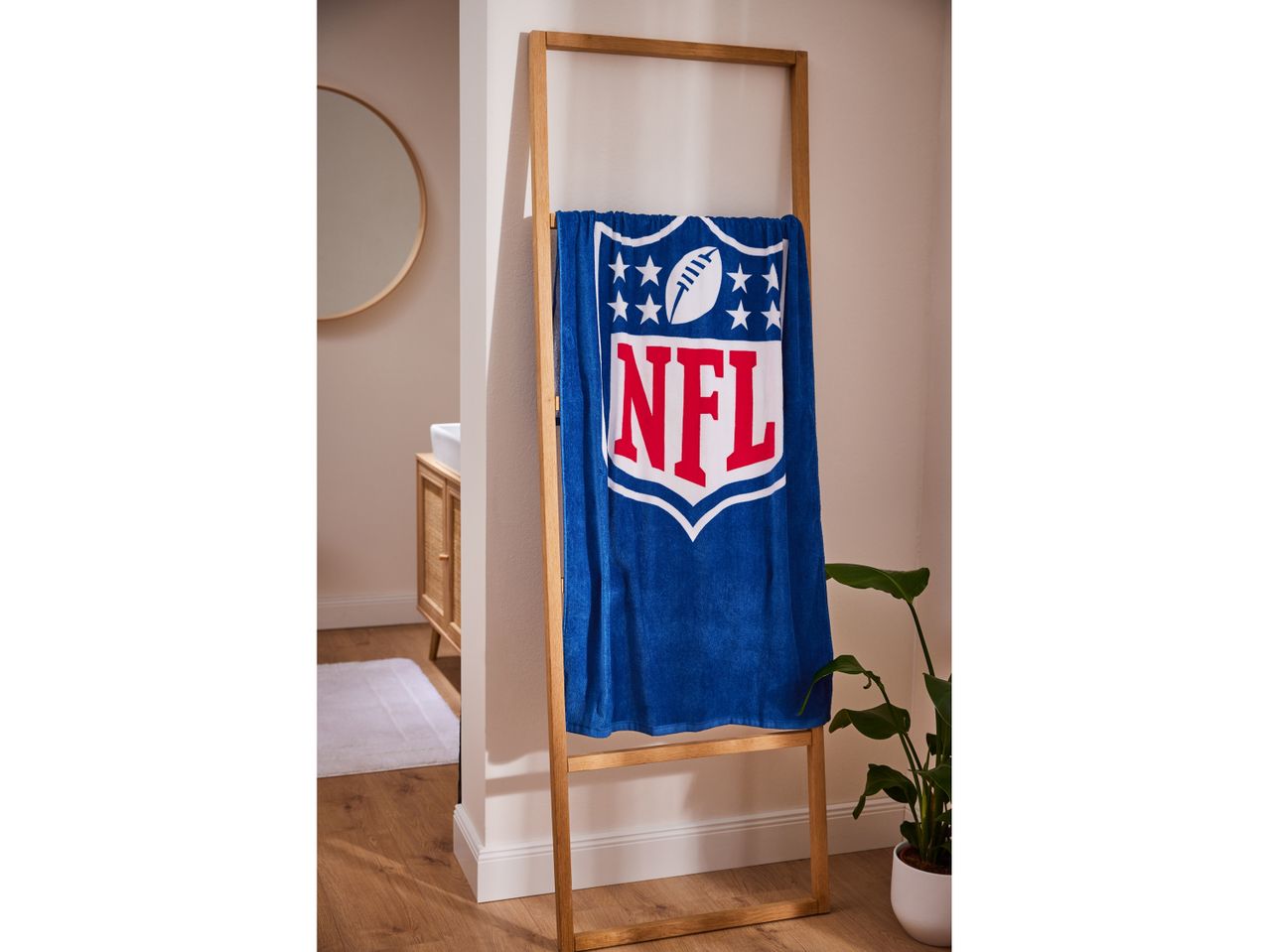 Asciugamano NFL a tema football americano su un portasciugamani di legno.