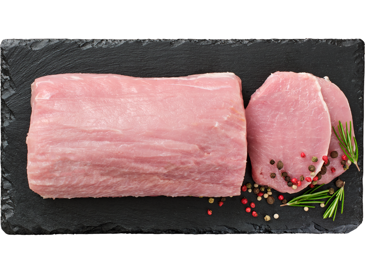 Jēla cūkgaļas karbonāde un divas cūkgaļas šķēles ar rozmarīnu un pipariem uz melna šīfera.