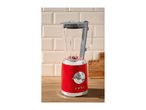 Red retro-style blender with a glass jug on a wooden countertop.